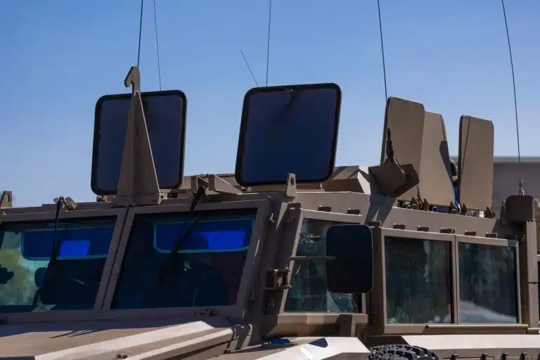 Véhicule militaire avec cage anti-drone en opération extérieure